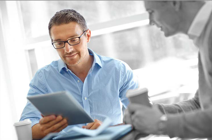 Man seating down at a desk looking at some paperwork