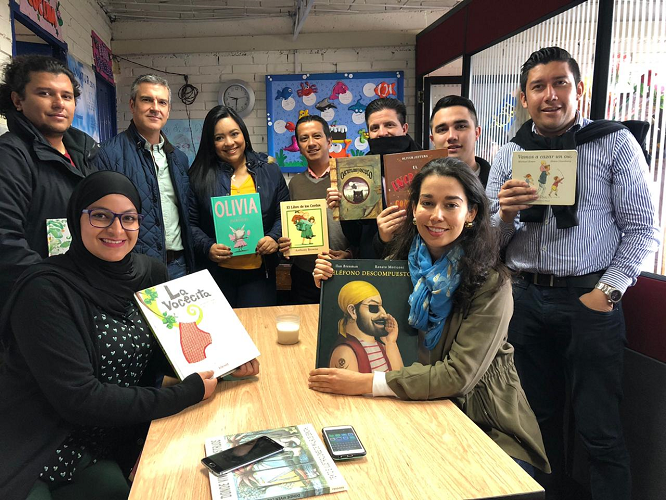 Assurant Employees Diverse Group of Assurant Employees Holding up Books